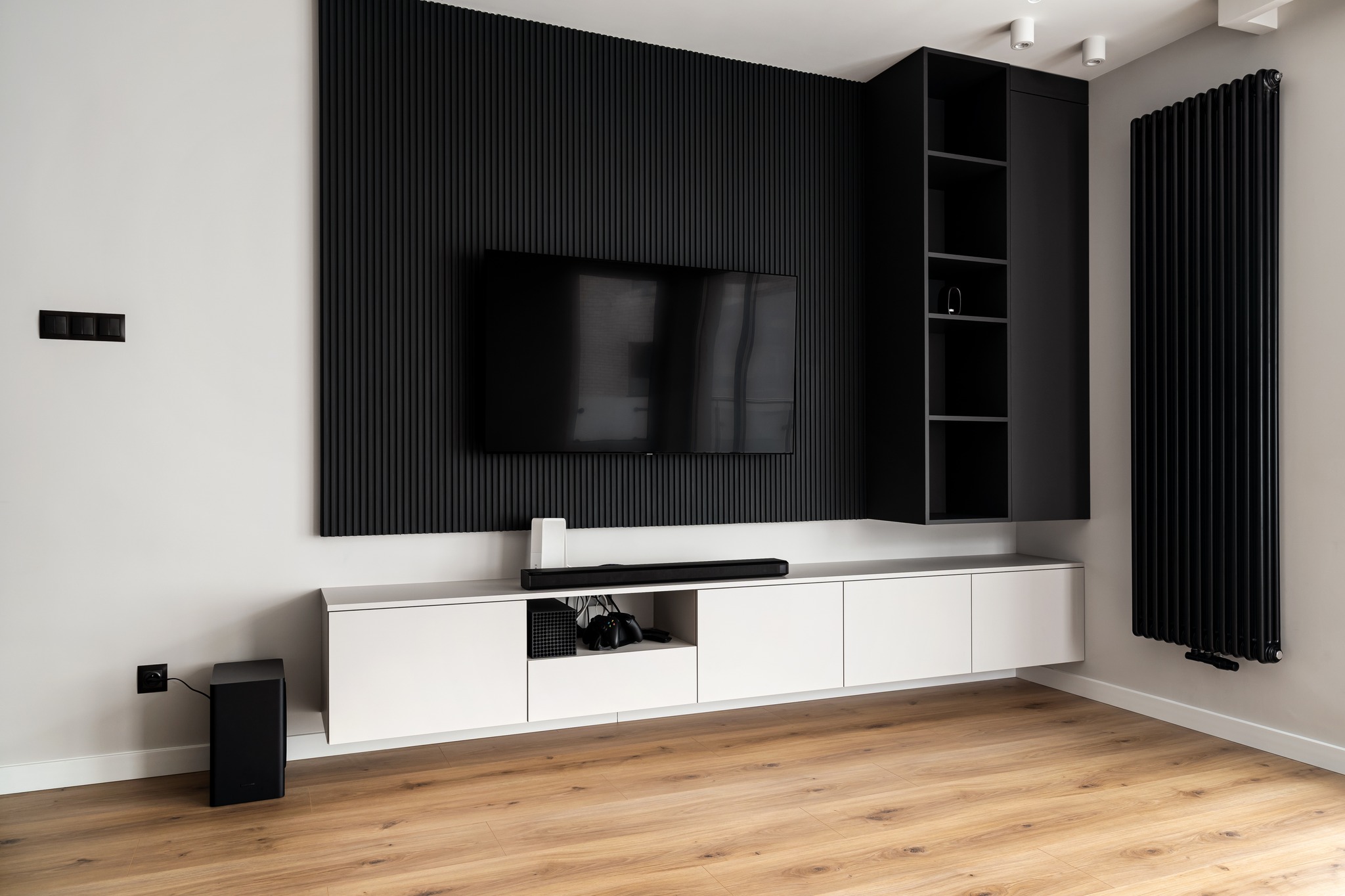 uz baltas sienas pielikti melni dekoratīvi sienas paneļi